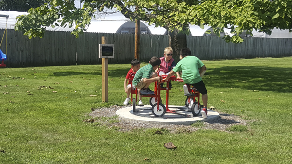 Children playing on the merry-go-round outside the office